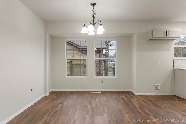 unfurnished dining area with dark wood-type flooring and a chandelier