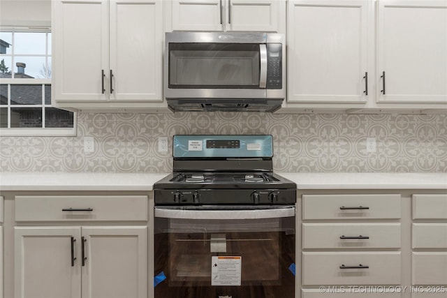 kitchen featuring white cabinets, backsplash, and black range with gas stovetop