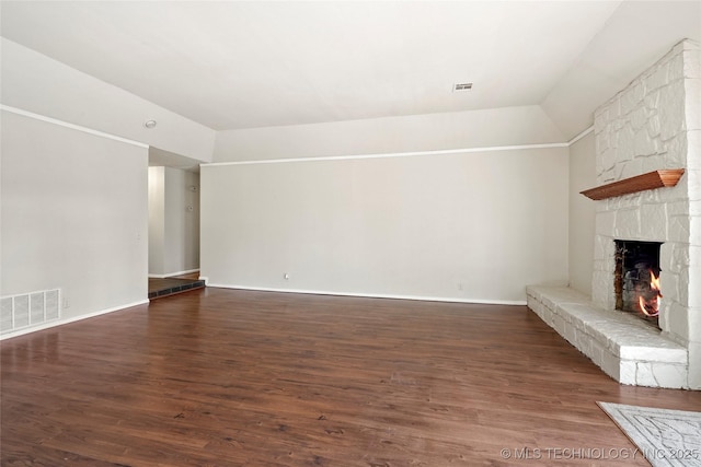 unfurnished living room featuring a stone fireplace, lofted ceiling, and dark hardwood / wood-style flooring