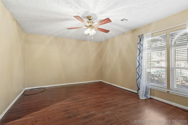 empty room with dark hardwood / wood-style floors, a textured ceiling, and ceiling fan