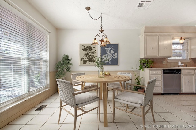 tiled dining area with an inviting chandelier