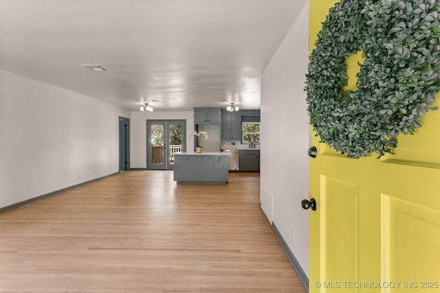 unfurnished living room with french doors and light hardwood / wood-style floors