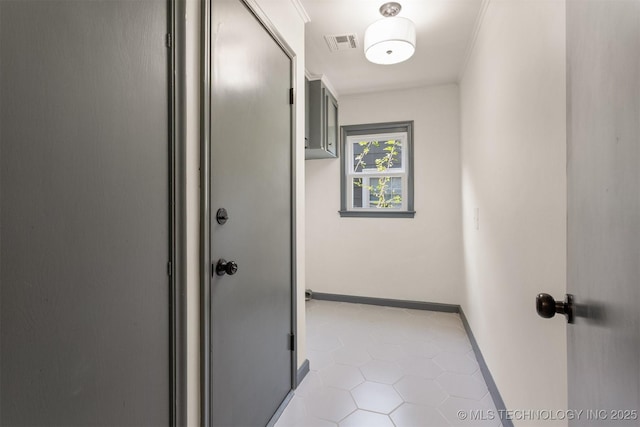 hallway with crown molding and light tile patterned flooring