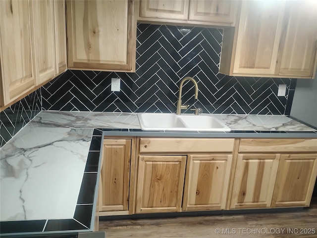 kitchen featuring decorative backsplash, sink, and light stone counters