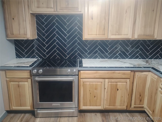 kitchen featuring oven, light stone counters, and tasteful backsplash