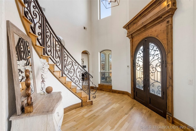 entryway featuring a high ceiling, light hardwood / wood-style flooring, and french doors