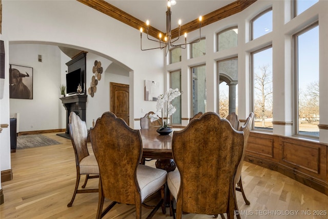 dining area featuring a notable chandelier, light hardwood / wood-style flooring, and crown molding