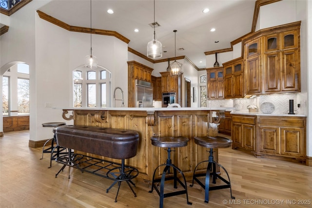 kitchen with decorative backsplash, hanging light fixtures, a large island, and stainless steel appliances