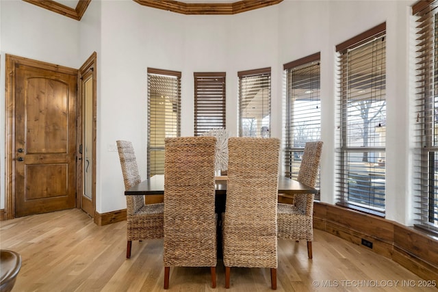 dining room featuring light wood-type flooring and ornamental molding