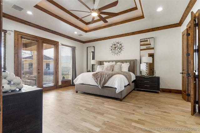 bedroom with ceiling fan, light hardwood / wood-style flooring, ornamental molding, and a tray ceiling