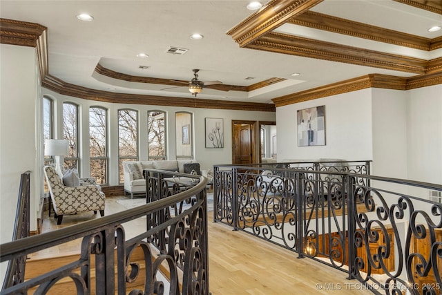 interior space with light hardwood / wood-style flooring, ornamental molding, and a raised ceiling