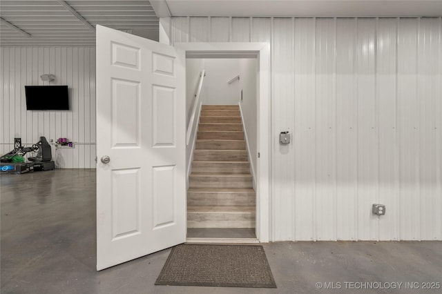 stairs with wooden walls and concrete flooring