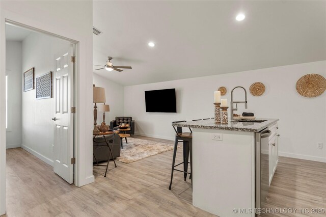 18342 S 132nd E Ave, Bixby, OK 74008 - kitchen with a kitchen breakfast bar, light wood-style flooring, a sink, visible vents, and a ceiling fan