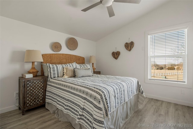 bedroom with ceiling fan, vaulted ceiling, and wood-type flooring