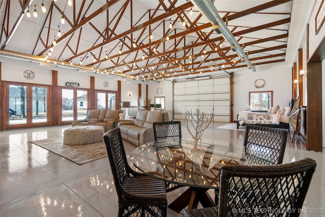 dining space featuring concrete floors, beam ceiling, high vaulted ceiling, and french doors