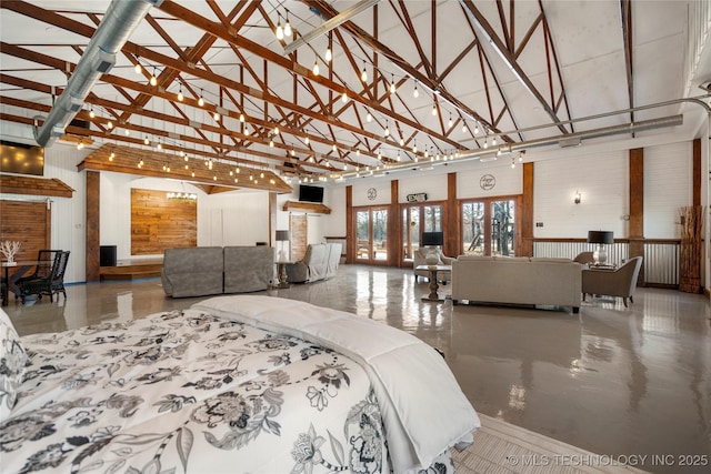 bedroom featuring wood walls, beamed ceiling, and high vaulted ceiling