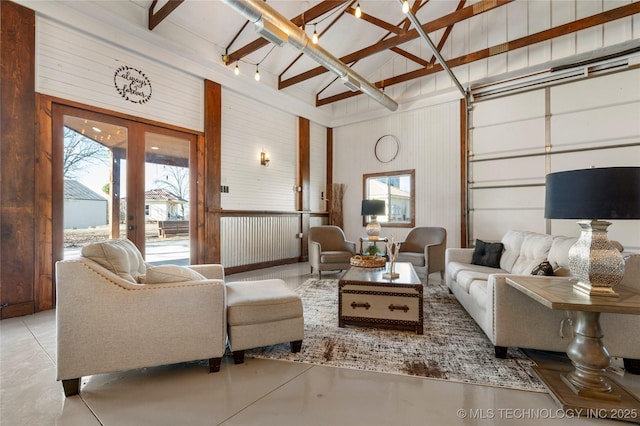 living room with high vaulted ceiling, beam ceiling, french doors, and wooden walls