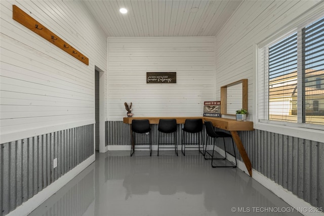 bar featuring wood walls and concrete flooring