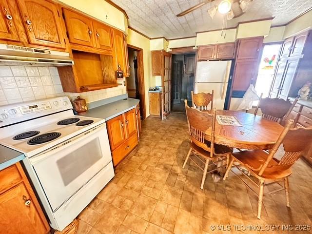 kitchen with decorative backsplash, white appliances, ornamental molding, and ceiling fan