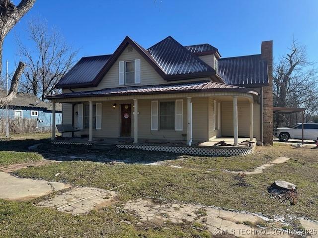 country-style home featuring covered porch and a front lawn