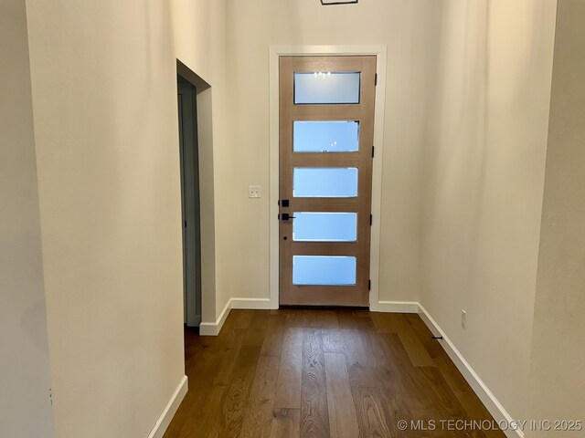 entryway featuring ornamental molding, a chandelier, and concrete floors