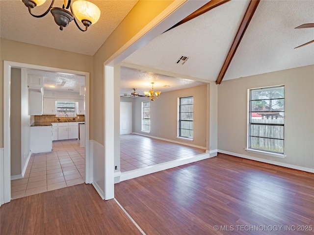 interior space featuring ceiling fan with notable chandelier, hardwood / wood-style floors, and a textured ceiling