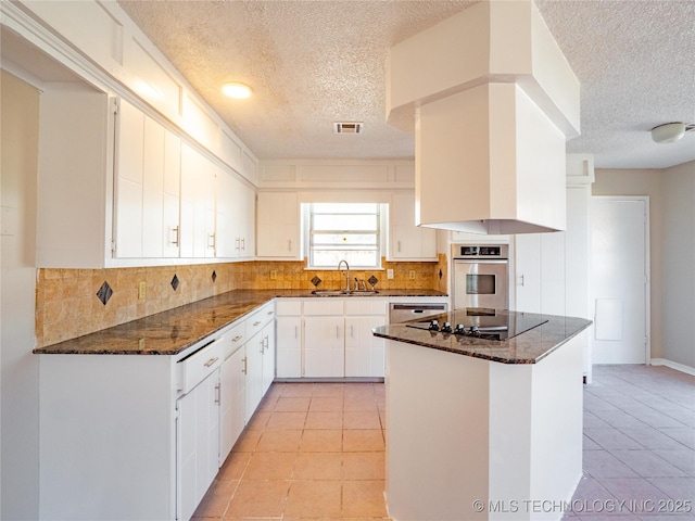 kitchen featuring kitchen peninsula, sink, white cabinetry, black electric stovetop, and stainless steel oven