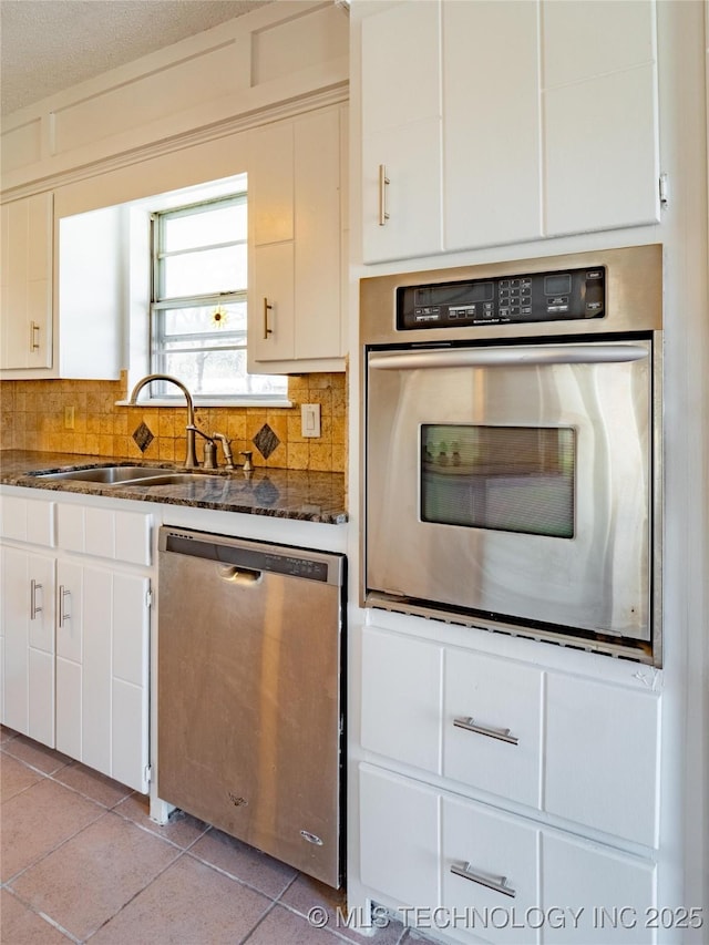 kitchen featuring sink, white cabinets, light tile patterned floors, and stainless steel appliances