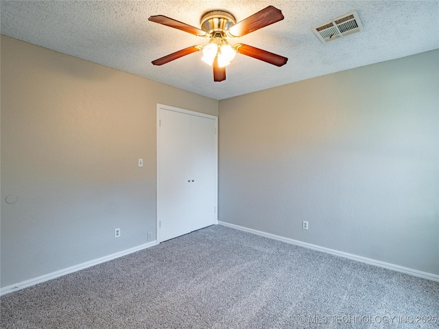 carpeted spare room with a textured ceiling and ceiling fan