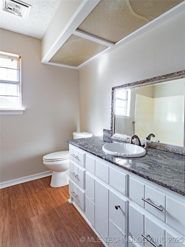 bathroom with hardwood / wood-style flooring, plenty of natural light, toilet, and vanity