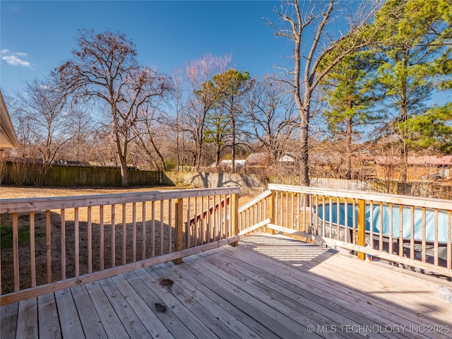 wooden deck with a fenced in pool