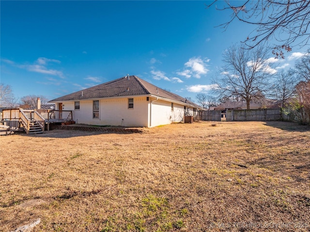 view of property exterior with a lawn and a wooden deck