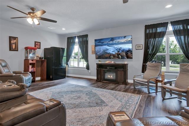 living room featuring a fireplace, ceiling fan, and dark hardwood / wood-style flooring