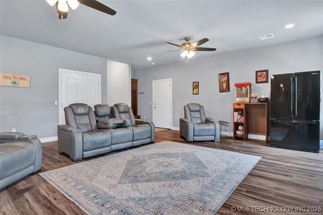 living room with ceiling fan and dark hardwood / wood-style floors