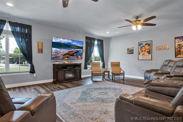 living room featuring ceiling fan, dark hardwood / wood-style floors, and a wealth of natural light