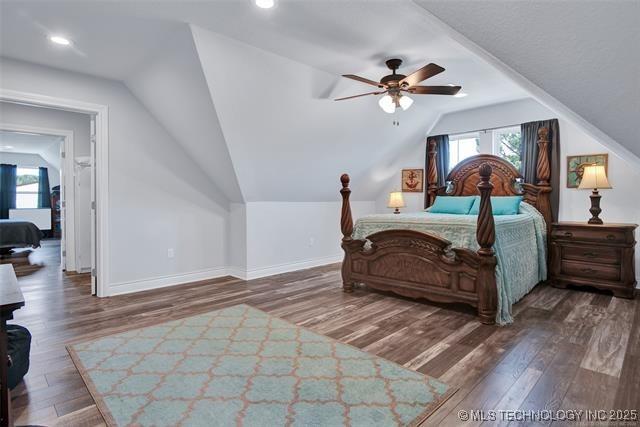 bedroom featuring dark hardwood / wood-style floors, vaulted ceiling, and ceiling fan