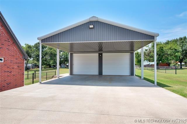 garage featuring a carport and a yard