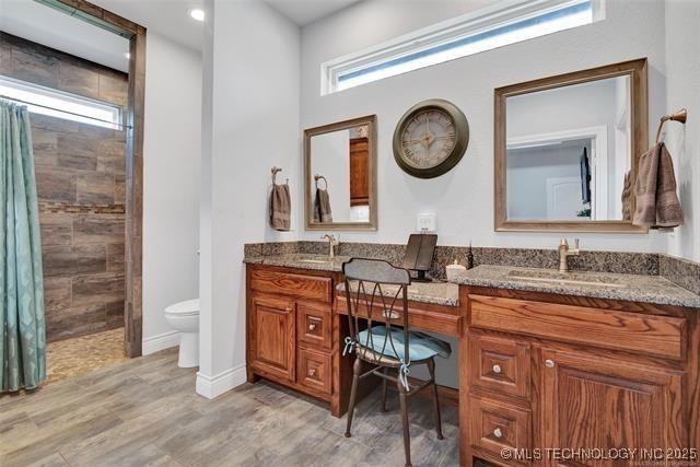 bathroom with vanity, a wealth of natural light, and a tile shower