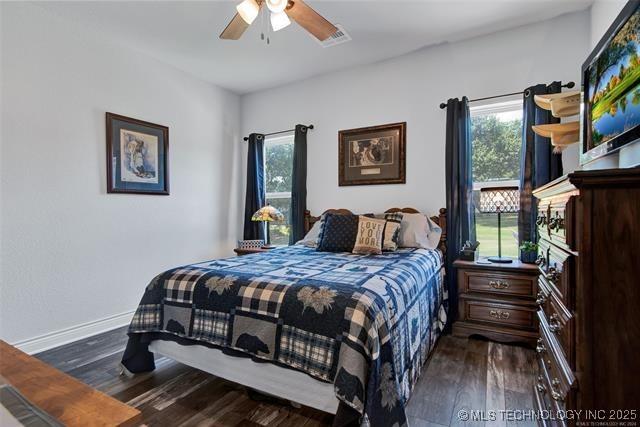 bedroom featuring ceiling fan and dark wood-type flooring