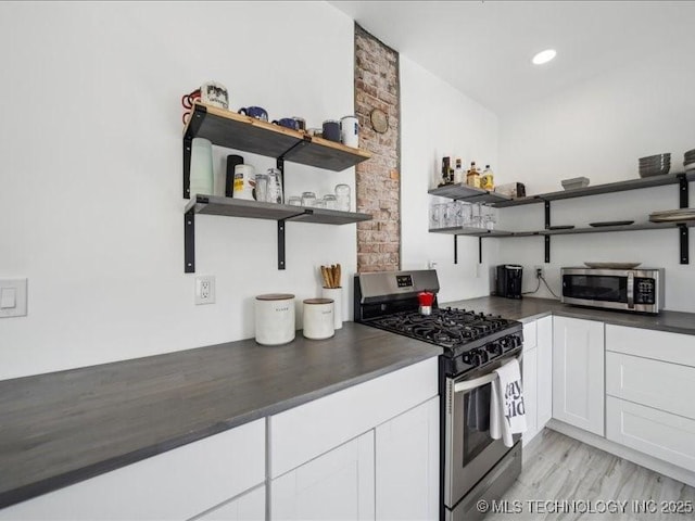 kitchen featuring white cabinets, light wood-type flooring, and appliances with stainless steel finishes