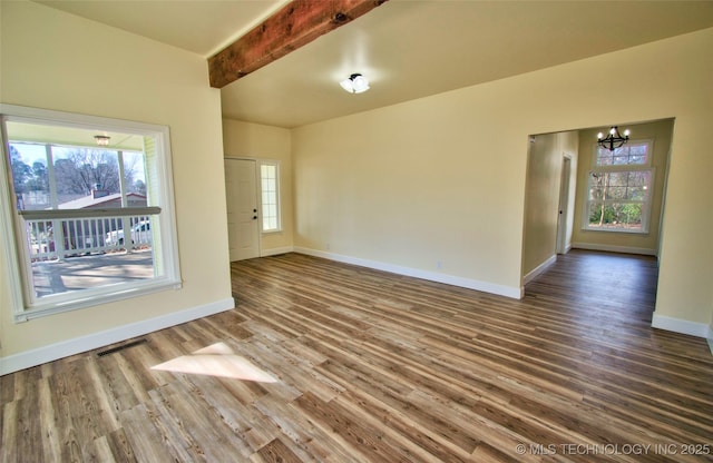 spare room featuring beam ceiling, an inviting chandelier, and wood-type flooring