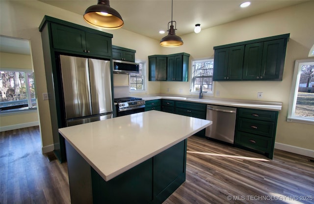 kitchen featuring a kitchen island, dark hardwood / wood-style flooring, pendant lighting, and appliances with stainless steel finishes