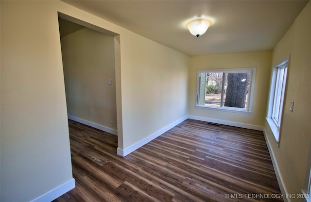 empty room with dark hardwood / wood-style flooring