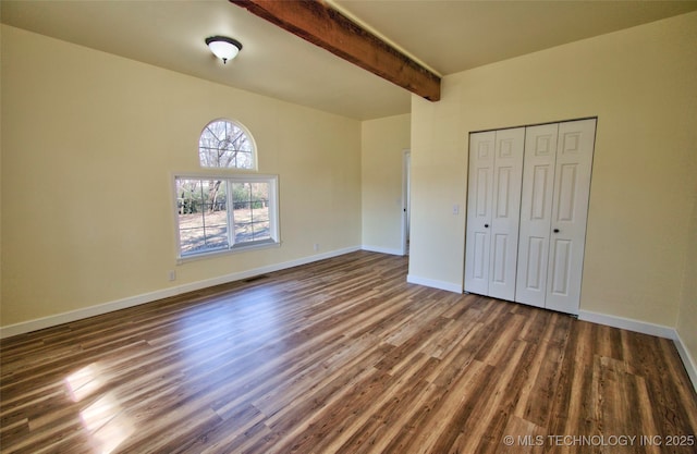 unfurnished bedroom featuring a closet, beam ceiling, and dark hardwood / wood-style flooring