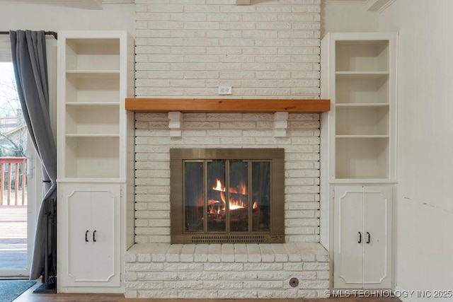 interior details with built in shelves and a brick fireplace