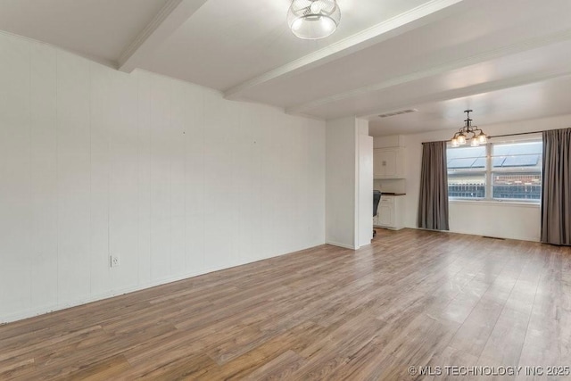 empty room featuring a chandelier, light hardwood / wood-style flooring, and beam ceiling