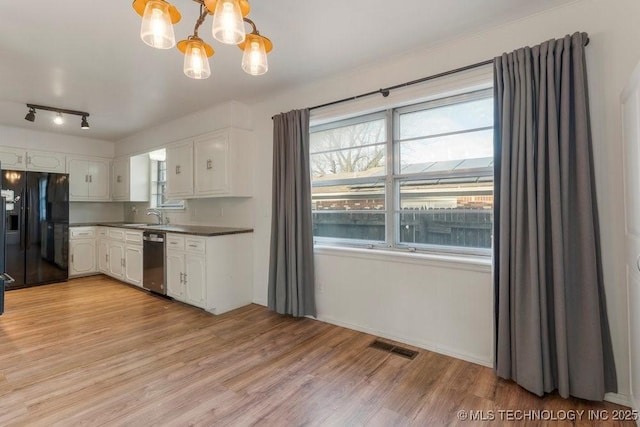 kitchen featuring white cabinetry, a chandelier, stainless steel dishwasher, pendant lighting, and black fridge