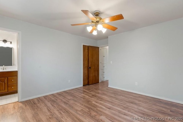 unfurnished bedroom with sink, light hardwood / wood-style floors, connected bathroom, and ceiling fan