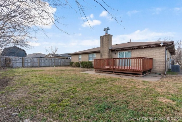 rear view of house with cooling unit, a deck, and a yard