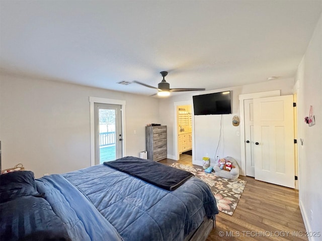 bedroom with hardwood / wood-style floors, ensuite bath, and ceiling fan